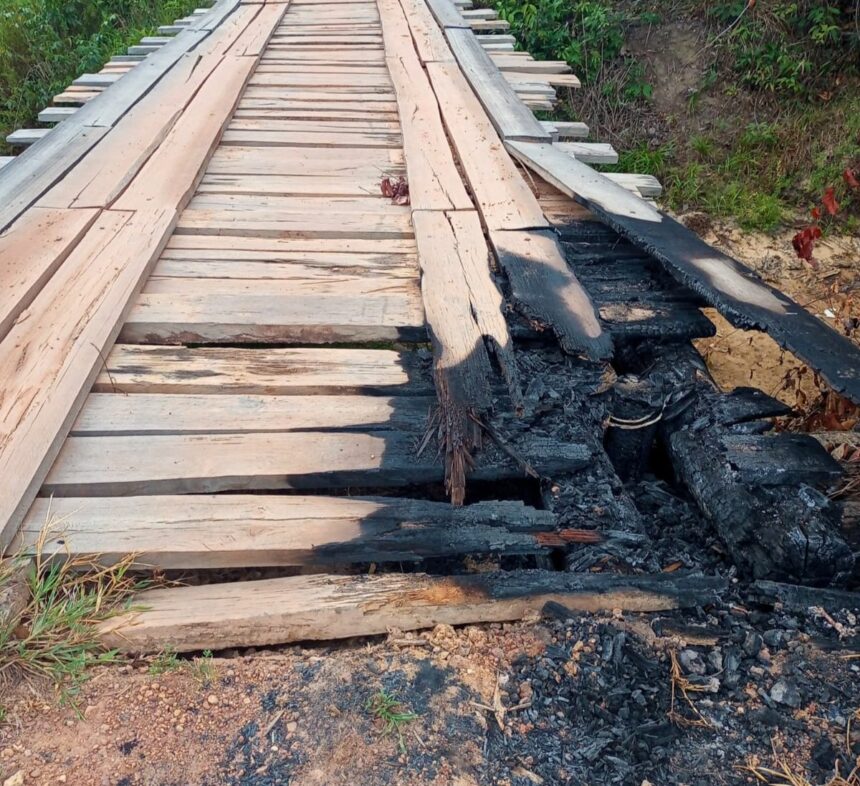 Com ponte de madeira queimada há três semanas, moradores relatam dificuldades de travessia em vicinal do Cantá; veja vídeo