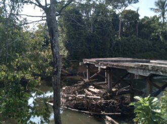Isolados há um ano e meio, moradores de comunidade indígena usam barco para travessia de rio após ponte ceder em Amajari: ‘ninguém se responsabiliza’