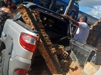 Motorista invade preferencial, colide com ônibus e destrói muro de casa