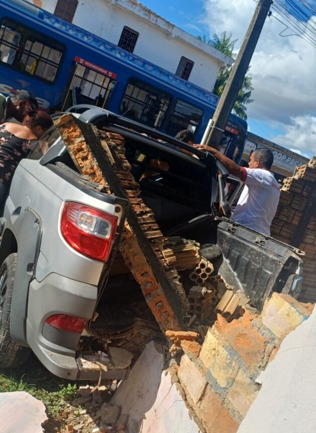 Motorista invade preferencial, colide com ônibus e destrói muro de casa
